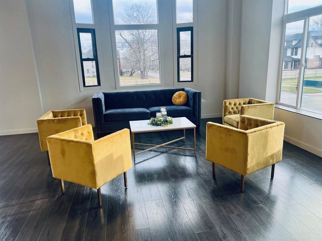 The lounge with a navy sofa and gold velvet chairs